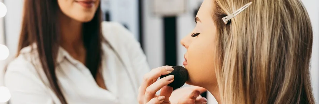 Professional makeup application using beauty sponge during a bridal makeup appointment