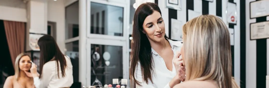 Client getting professional makeup service at beauty studio
